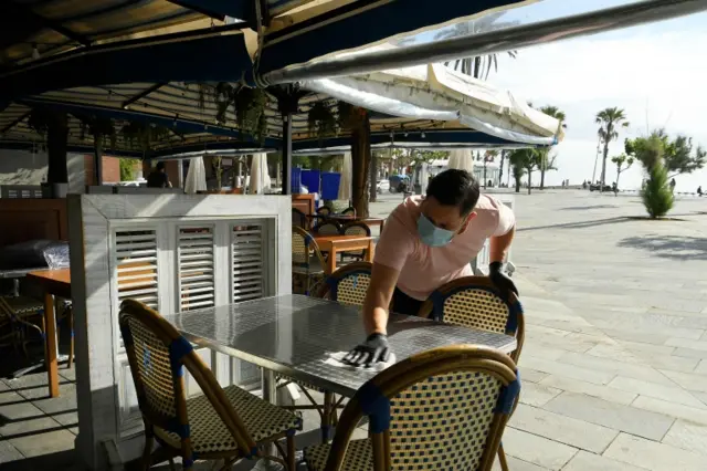 A man cleans tables at a bar in Barcelona