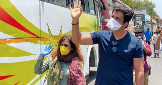 A picture of Sonu Sood outside a bus that he arranged to take migrant workers home