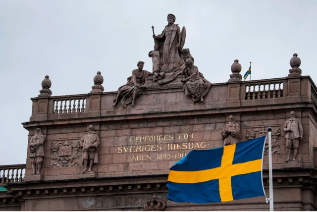 The Swedish flag flies in front of the Swedish Parliament in Stockholm during the coronavirus pandemic