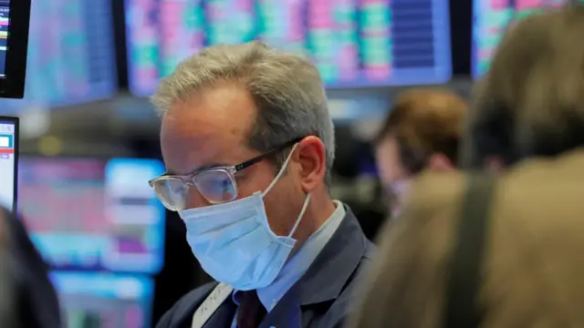 A trader wears a mask as he works on the floor of the New York Stock Exchange.