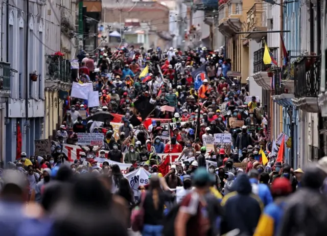 People protest against lower wages and budget cuts imposed by the government amid the new coronavirus pandemic in downtown Quito