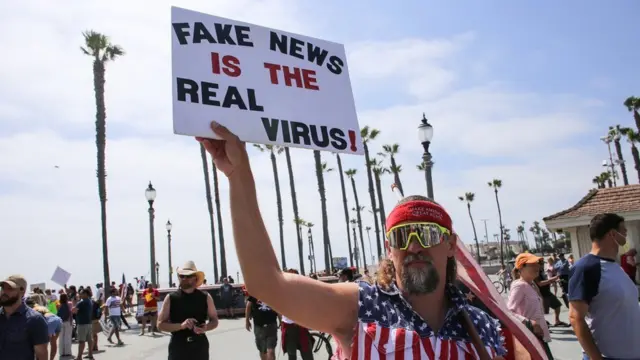 A man in the US holds up a sign about fake news