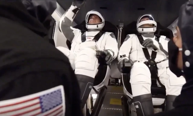 astronauts buckled in