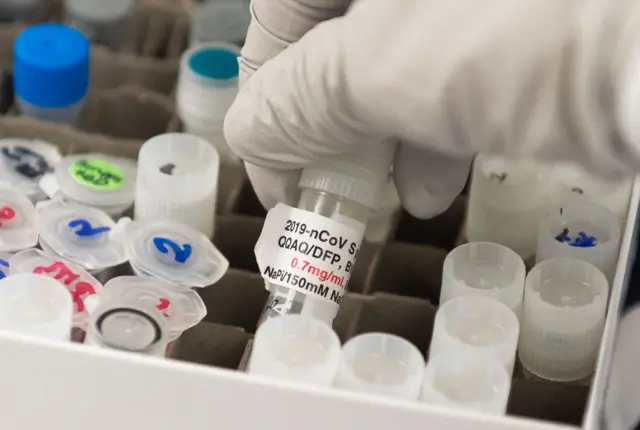 Dr. Nita Patel, Director of Antibody discovery and Vaccine development, lifts a vial with a potential coronavirus, COVID-19, vaccine at Novavax labs in Gaithersburg, Maryland on 20 March, 2020