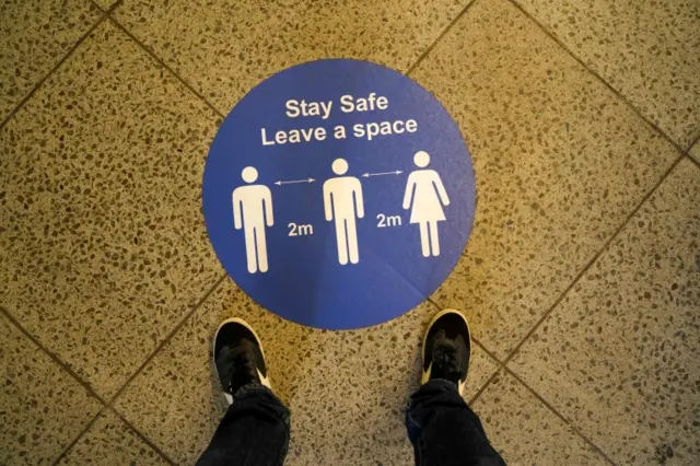 Social distancing advice is seen inside Westminster underground station in London