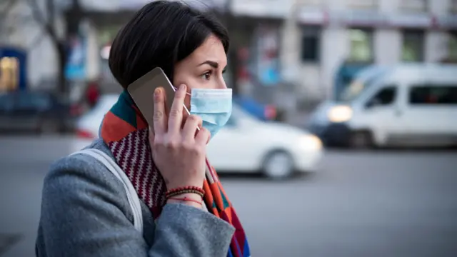 A woman wearing a mask on a mobile