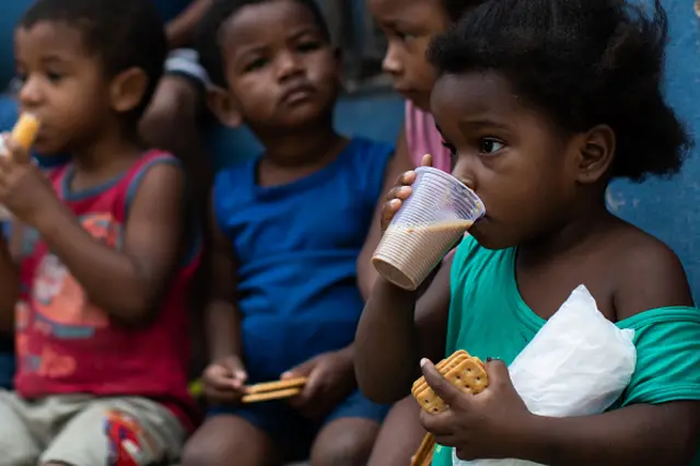 Kids eat breakfast during the donation of food in Brazil