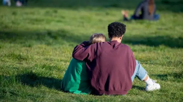 A couple hug in a UK park