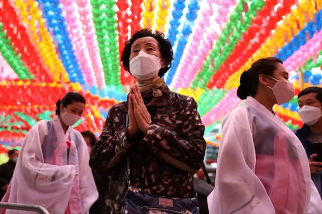 A buddhist believer wears a mask