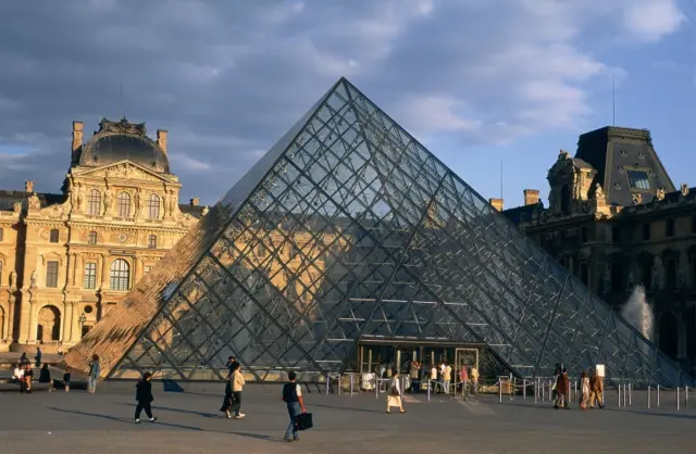 People entering the Louvre in Paris through its famous Pyramid