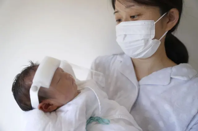 Mother in mask, baby in shield