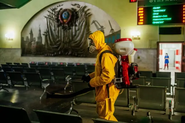 A serviceman of Russia"s Emergencies Ministry wearing a protective gear disinfects Moscow"s Kazansky railway station on May 28, 2020