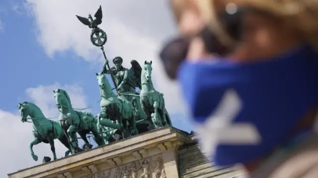 Woman with face mask in front of Brandenburg Gate