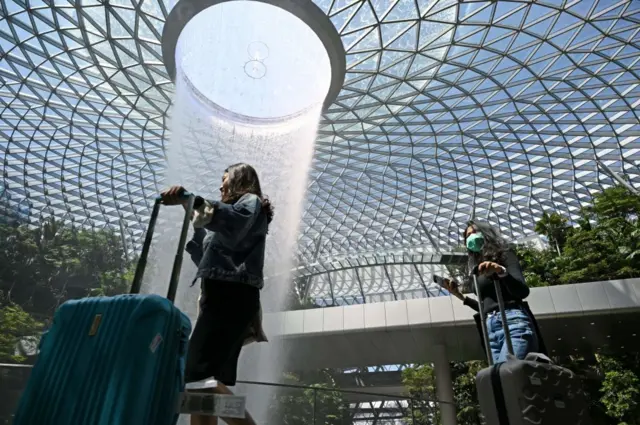 A traveller (R), wearing a protective facemask amid fears about the spread of the COVID-19 novel coronavirus,