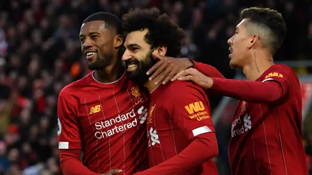 Liverpool players Gini Wijnaldum, Mohamed Salah and Roberto Firmino celebrate scoring a goal