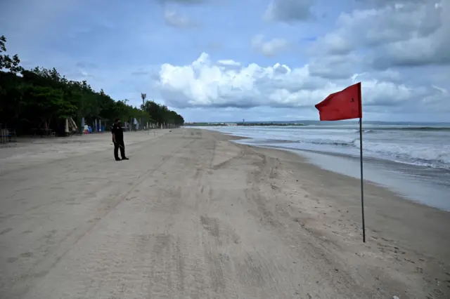 Red flag on empty beach in Bali