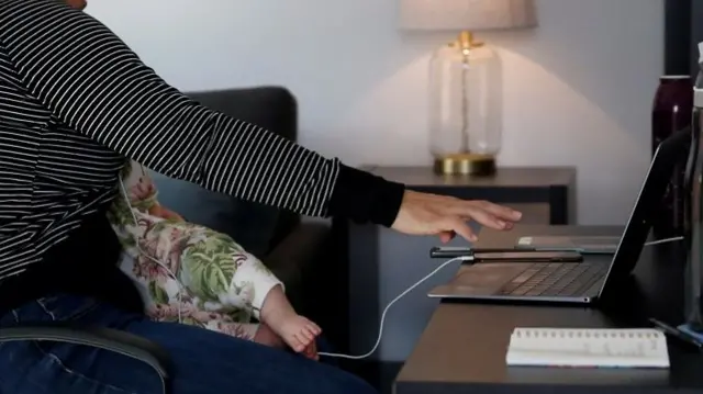 Mother breastfeeds while on a work call