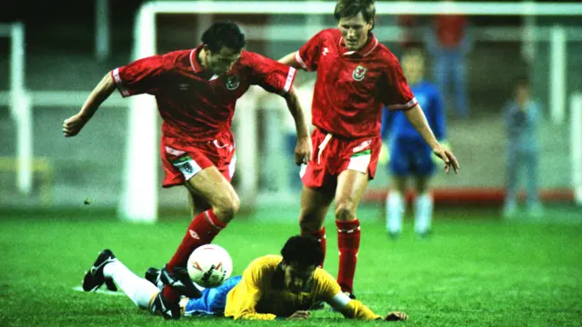 Wales midfielder Barry Horne leaves Brazil captain Careca sprawled on the Cardiff turf