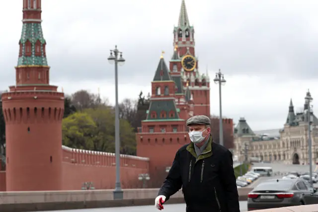 A man in a face mask walks on Bolshoi Moskvoretsky Bridge near Red Square