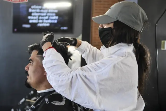 A hairdresser in Colorado gives a man a trim