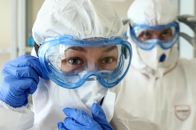 Medics put on protective gear before entering a Covid-19 treatment facility in Russia