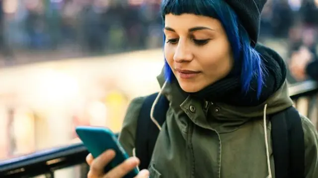 A woman looks at her phone