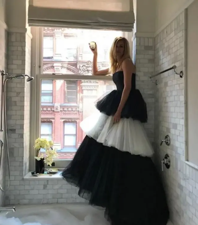 Julia Roberts in black and white tulle gown, posing at a window in a bathroom, taken from her Instagram