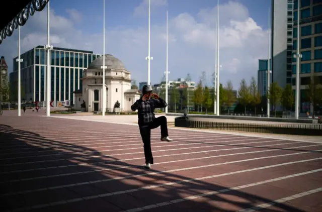 Woman practices Tai Chi in deserted city centre