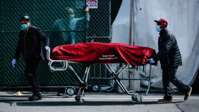 Health workers carrying a bodybag