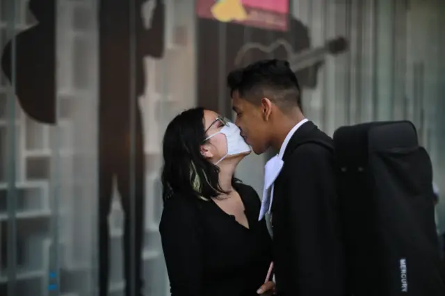 A musician of the band Maricahi Cultural kisses his girlfriend during a recording at the Museo del Tequila y el Mezcal