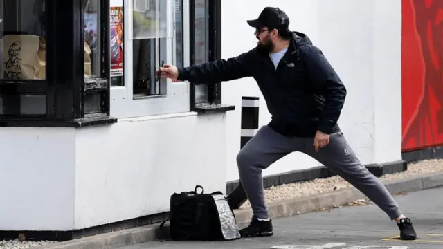 Man holds a phone up to a window