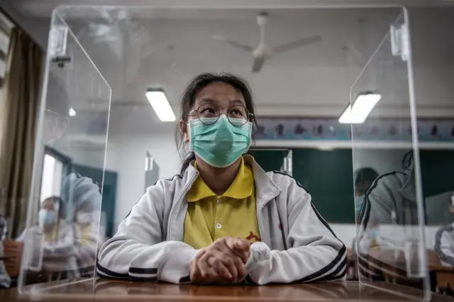 A high school senior student studies behind a plastic partition in a classroom in Wuhan in China"s central Hubei province on May 6, 2020.