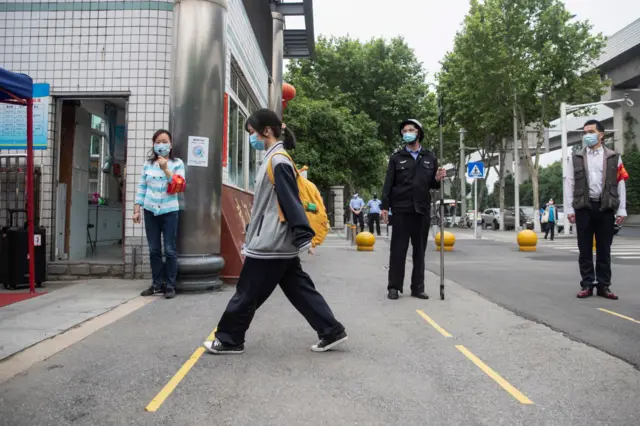 A senior student (C) enters a high school in Wuhan in China's central Hubei province on May 6, 2020.