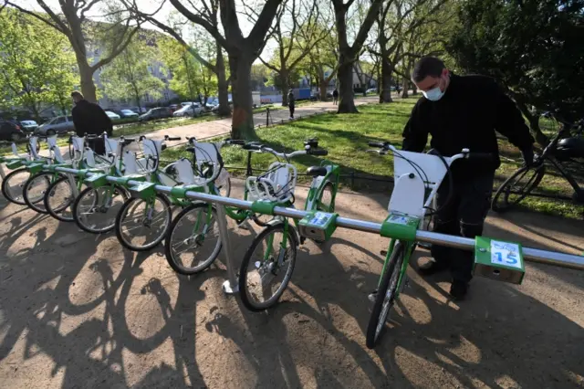 A worker at a bike rental prepares urban bikes at a park in Szczecin, northwestern Poland