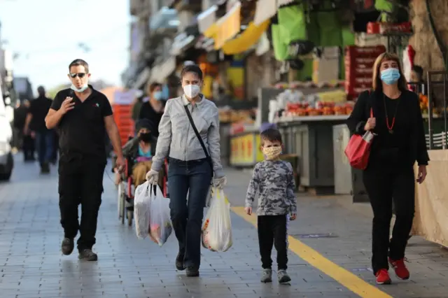 People walk through the Mahane Yehuda Market in Jerusalem on 7 May 2020