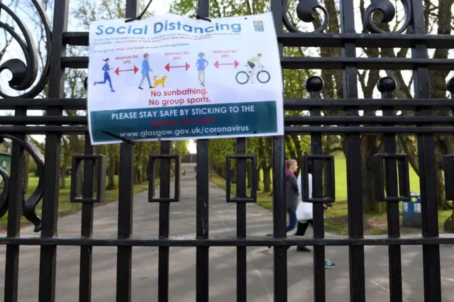 A poster about social distancing guidelines on a park gate in Glasgow