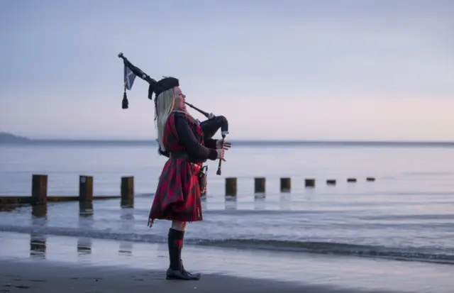 Piper Louise Marshall plays at dawn along Edinburgh"s Portobello Beach overlooking the Firth of Forth on the 75th anniversary of VE Day.