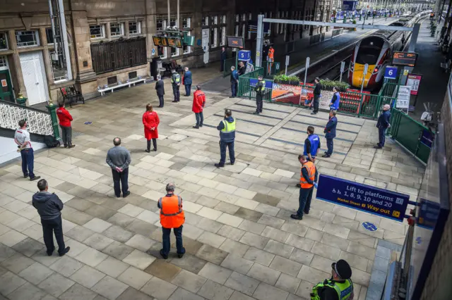 Railway staff at Waverley Station mark the 75th anniversary of VE day with a two-minute silence