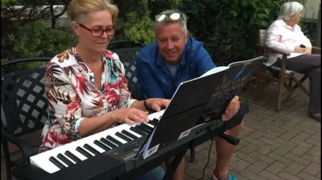 Man and woman play piano