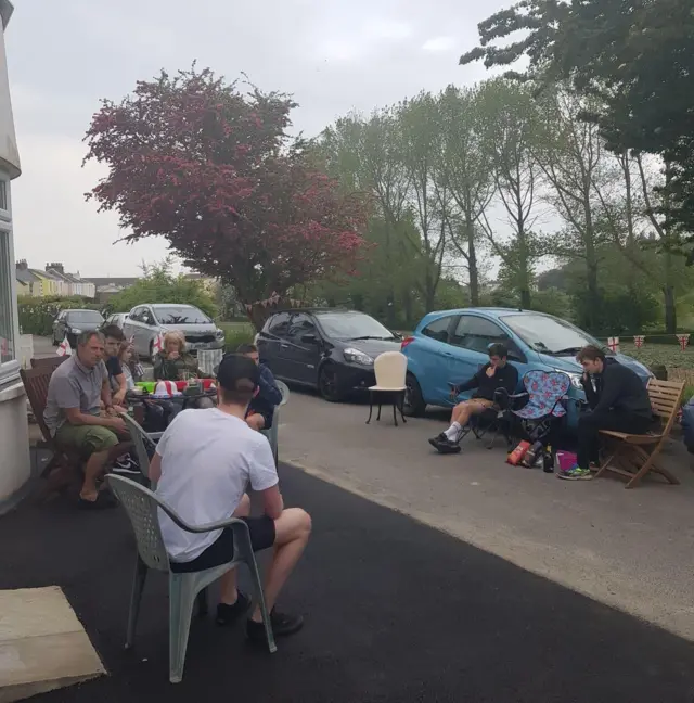 Group sit at a social distance in street