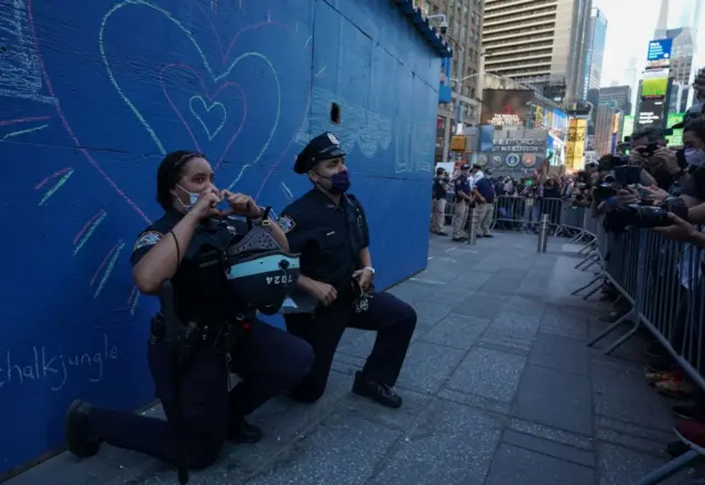 Two New York City police officers take a knee during a demonstration by protesters in Times Square over the death of George Floyd