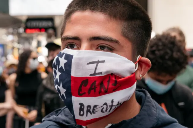 Protester wears an American flag face mask with the words "I can't breathe"