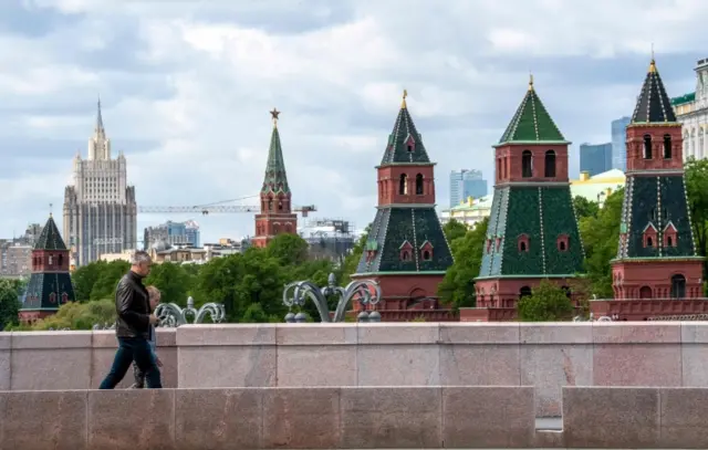 People walk past the Kremlin