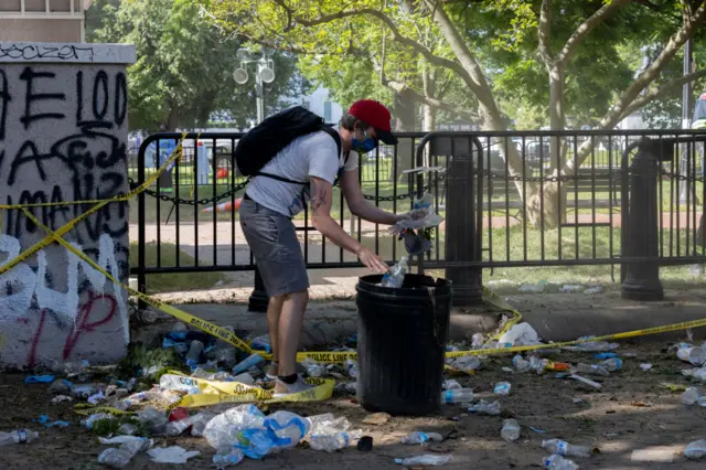 A man outside the White House appeared to be picking up rubbish to throw in a bin