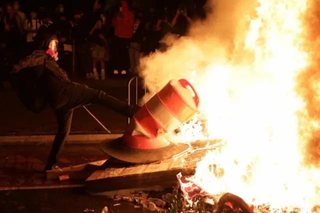 A protester near a burning barricade in Washington DC. Photo: 31 May 2020