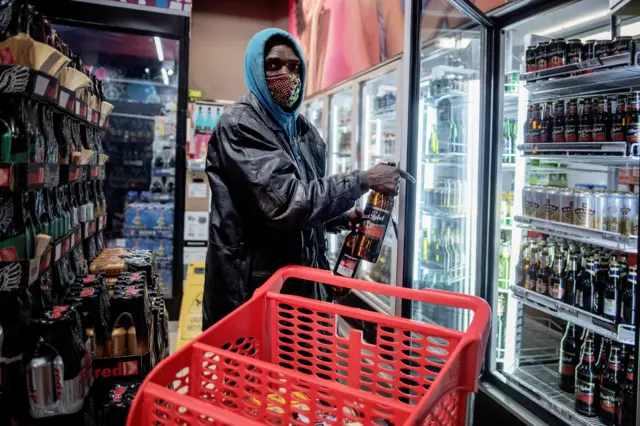 A man takes beers from a fridge inside a liquor shop in Melville, Johannesburg