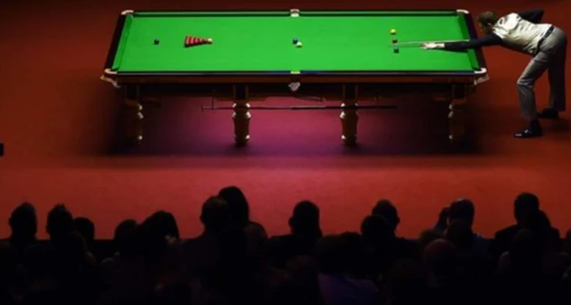 A snooker match with the audience looking on