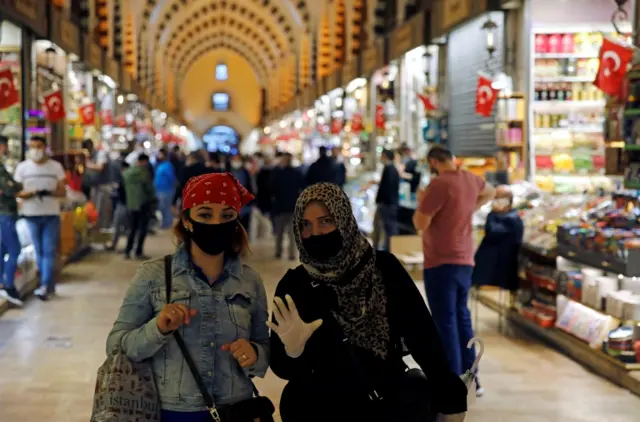 Two people wearing masks visit the market on its first day of opening