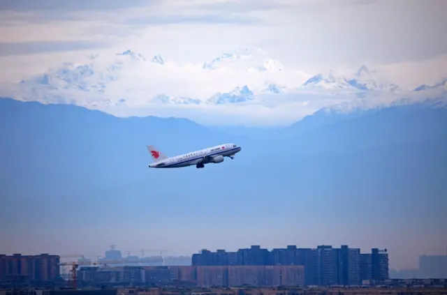 Planes Flies In Front Of Snowcapped Mountain In Sichuan