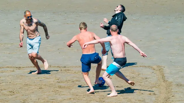 Adults play football on Portobello Beach on Sunday